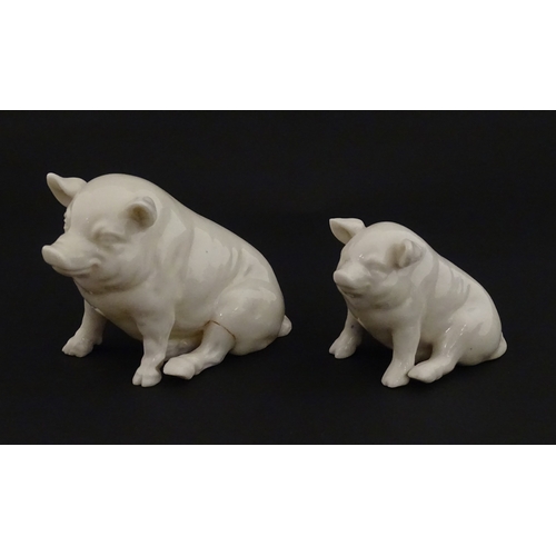 74 - Two Belleek models of seated pigs. Both marked with Second Period mark under. Largest approx. 3