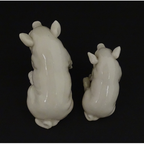 74 - Two Belleek models of seated pigs. Both marked with Second Period mark under. Largest approx. 3