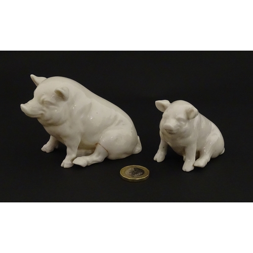 74 - Two Belleek models of seated pigs. Both marked with Second Period mark under. Largest approx. 3