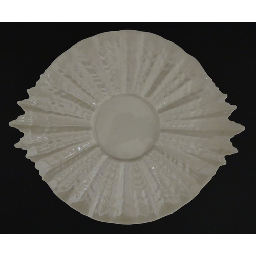 77 - A Belleek Tridacna pattern cake / bread plate. Marked with Second Period mark under. Approx. 11 1/2