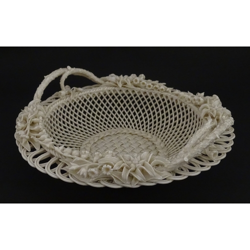 78 - A Belleek three strand Lily Basket having lattice work with ribbon edges, decorated with lily of the... 