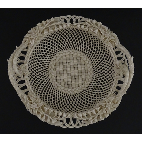 78 - A Belleek three strand Lily Basket having lattice work with ribbon edges, decorated with lily of the... 