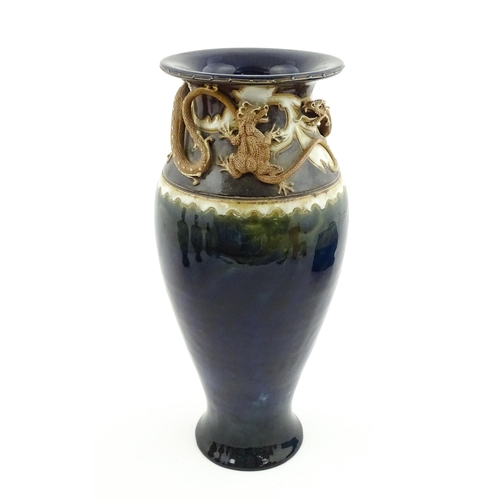 105 - A Royal Doulton vase with blue glaze and high relief dragon decoration to rim by Mark V Marshall. Ma... 