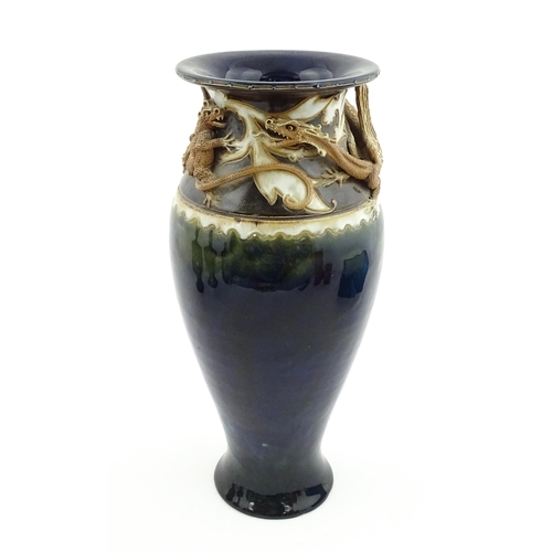 105 - A Royal Doulton vase with blue glaze and high relief dragon decoration to rim by Mark V Marshall. Ma... 