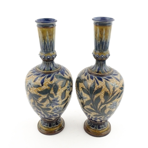 107 - A pair of Doulton Lambeth stoneware vases with  floral and foliate decoration. Marked under,  bearin... 