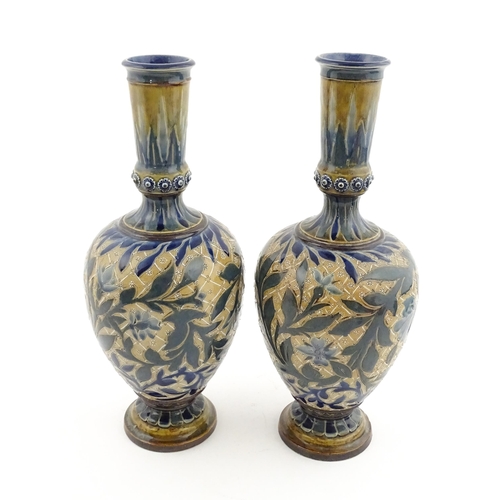 107 - A pair of Doulton Lambeth stoneware vases with  floral and foliate decoration. Marked under,  bearin... 