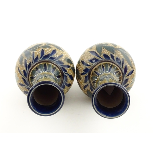 107 - A pair of Doulton Lambeth stoneware vases with  floral and foliate decoration. Marked under,  bearin... 