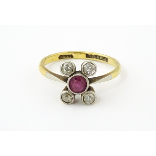 An 18ct gold ring with platinum set central ruby and four diamonds. Ring size approx. P 1/2