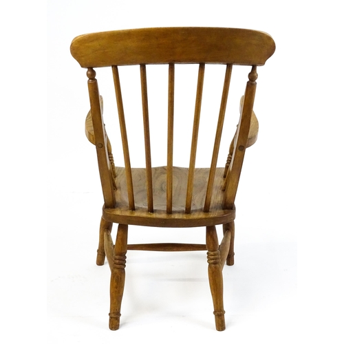 A late 19thC Windsor chair with a spindle back above an elm seat