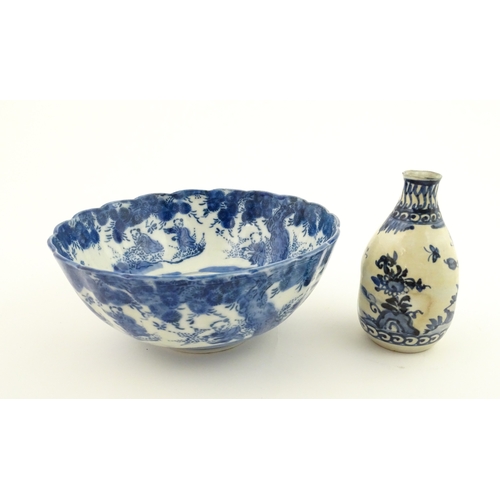 21A - A Chinese blue and white bottle vase with pinch detail decorated with a figure in a landscape. Toget... 