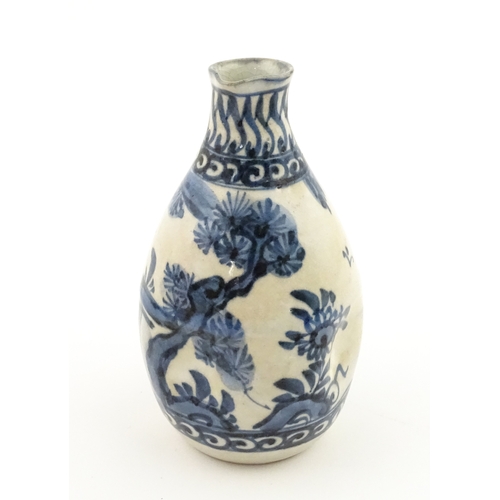 21A - A Chinese blue and white bottle vase with pinch detail decorated with a figure in a landscape. Toget... 