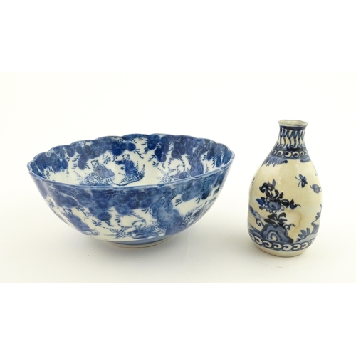 21A - A Chinese blue and white bottle vase with pinch detail decorated with a figure in a landscape. Toget... 