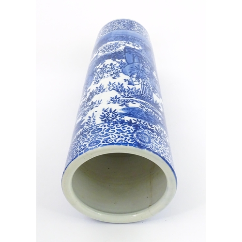 30 - A Chinese blue and white umbrella / stick stand decorated with figures and bamboo. Approx. 24 1/4