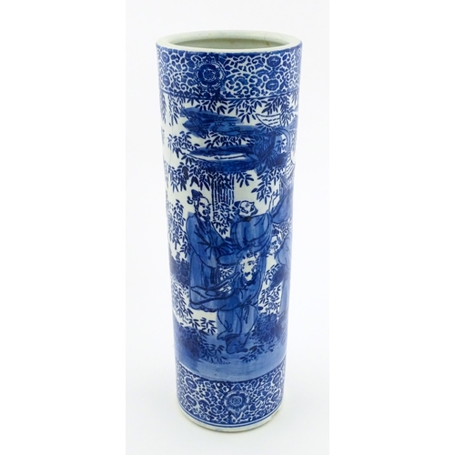 30 - A Chinese blue and white umbrella / stick stand decorated with figures and bamboo. Approx. 24 1/4