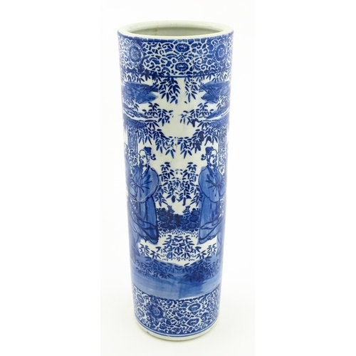 30 - A Chinese blue and white umbrella / stick stand decorated with figures and bamboo. Approx. 24 1/4