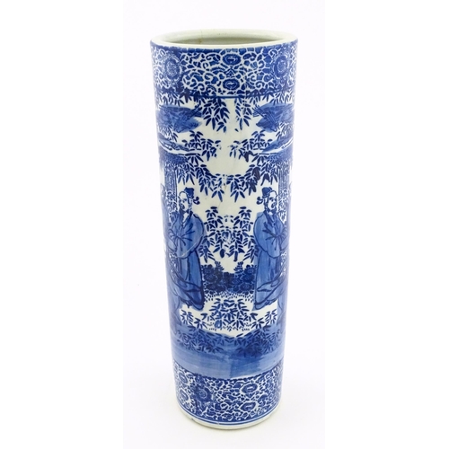30 - A Chinese blue and white umbrella / stick stand decorated with figures and bamboo. Approx. 24 1/4