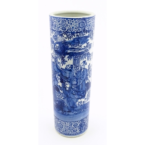 30 - A Chinese blue and white umbrella / stick stand decorated with figures and bamboo. Approx. 24 1/4