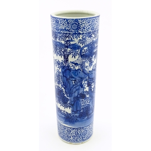 30 - A Chinese blue and white umbrella / stick stand decorated with figures and bamboo. Approx. 24 1/4