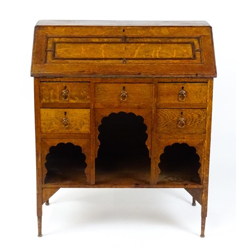 An Arts and Crafts oak Moorish Medina bureau designed by Leonard Francis Wyburd, (L.F Wyburd) for Liberty & Co. 31" wide x 15" deep x 37" high.