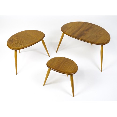 1666 - Vintage / Retro: An Ercol elm nest of three graduated 'pebble' tables raised on turned tapering legs... 