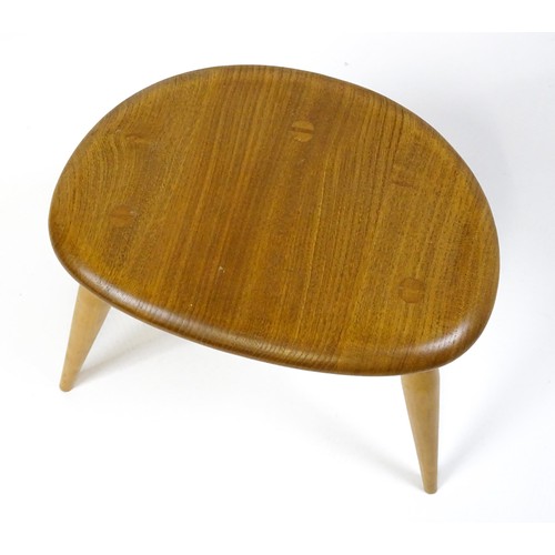 1666 - Vintage / Retro: An Ercol elm nest of three graduated 'pebble' tables raised on turned tapering legs... 