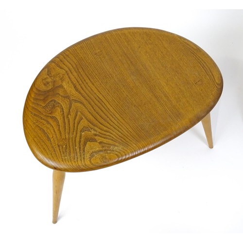 1666 - Vintage / Retro: An Ercol elm nest of three graduated 'pebble' tables raised on turned tapering legs... 