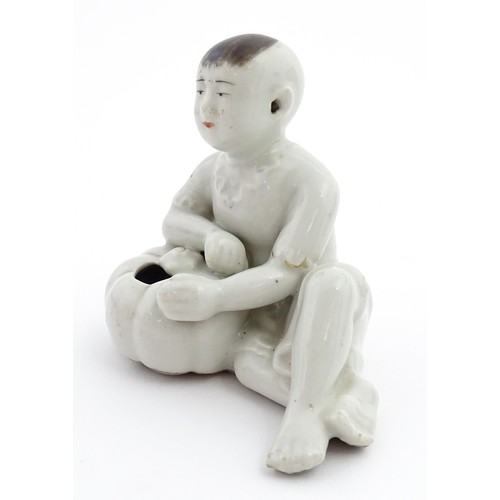 28 - A Chinese model of a seated boy with a pumpkin. Approx. 3 1/2