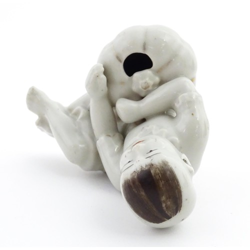 28 - A Chinese model of a seated boy with a pumpkin. Approx. 3 1/2