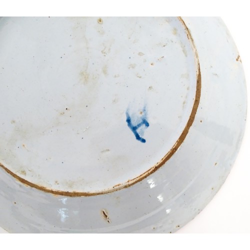 68 - A Delft blue and white plate decorated in the Chinese style with taihu rock, birds, flowers and foli... 