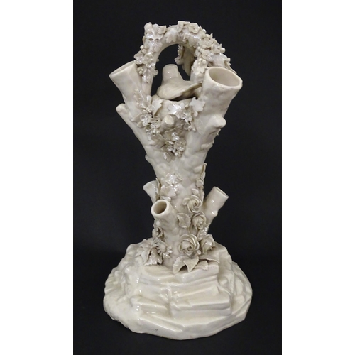 98 - A Belleek Bird Nest Stump vase with floral, foliate and bird decoration. Marked under with Second Pe... 