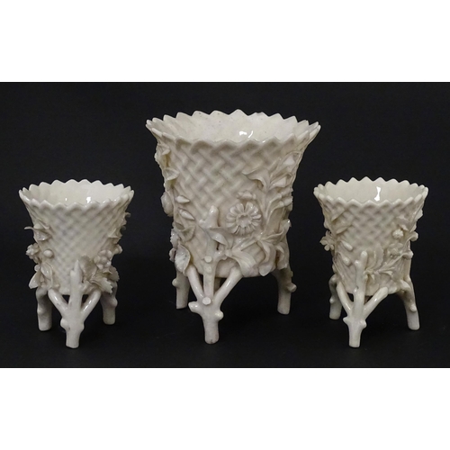 99 - Three Belleek Flowered Spill vases of basket form with floral and foliate decoration and raised on t... 
