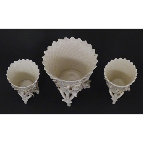 99 - Three Belleek Flowered Spill vases of basket form with floral and foliate decoration and raised on t... 