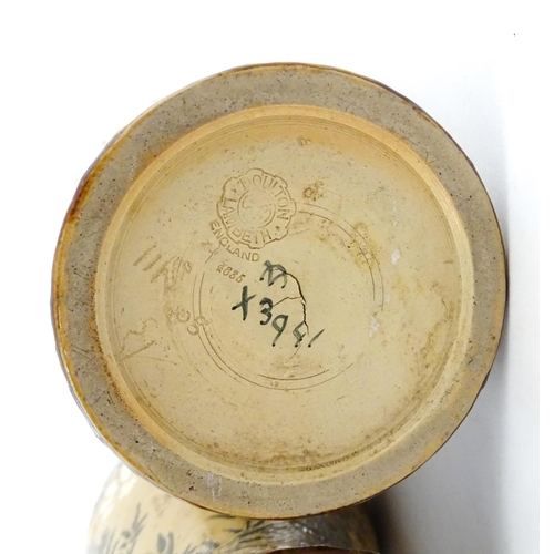 104 - A pair of Doulton Lambeth stoneware grotesque ewers / pitchers, the bodies decorated with carp fish ... 