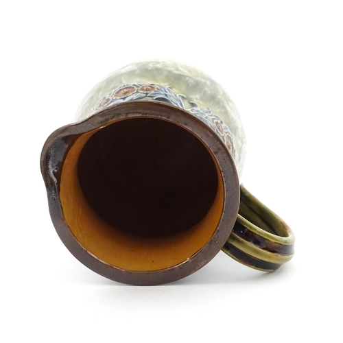 106 - A Royal Doulton stoneware water filter and jug with lid, the mottled green glaze with scrolling and ... 