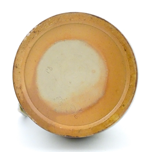 106 - A Royal Doulton stoneware water filter and jug with lid, the mottled green glaze with scrolling and ... 