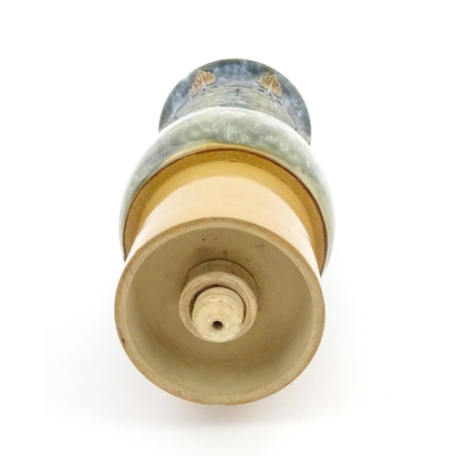 106 - A Royal Doulton stoneware water filter and jug with lid, the mottled green glaze with scrolling and ... 