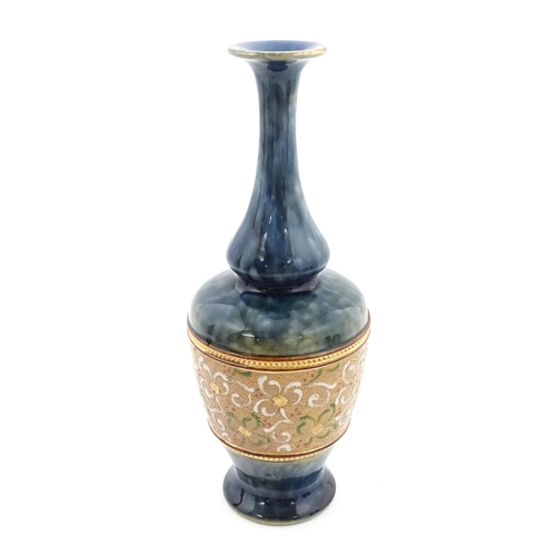 107 - A Royal Doulton bottle vase the mottled blue glaze with banded floral and foliate decoration. Marked... 