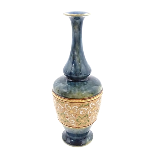 107 - A Royal Doulton bottle vase the mottled blue glaze with banded floral and foliate decoration. Marked... 