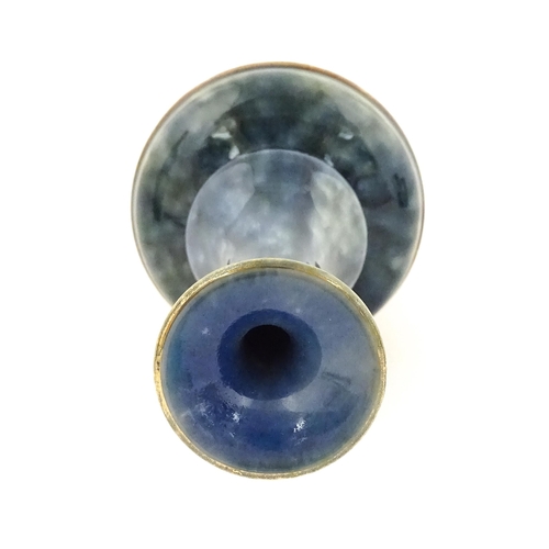 107 - A Royal Doulton bottle vase the mottled blue glaze with banded floral and foliate decoration. Marked... 