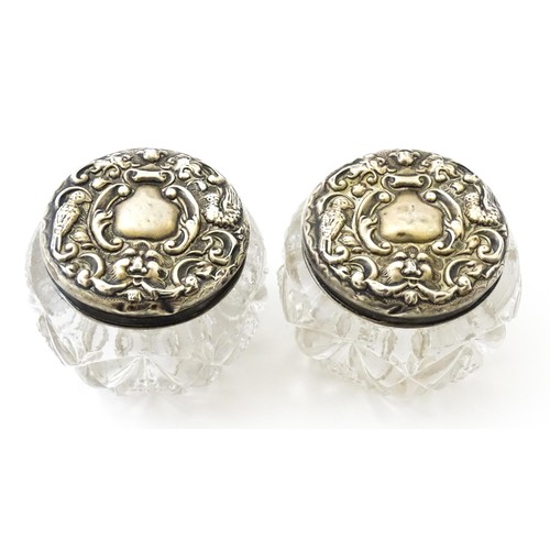 381 - A pair of cut glass dressing table pots with silver lids. Together with another. (3)