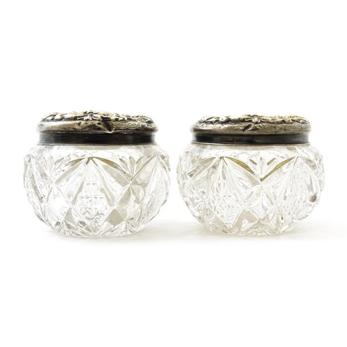 381 - A pair of cut glass dressing table pots with silver lids. Together with another. (3)