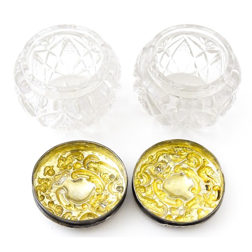 381 - A pair of cut glass dressing table pots with silver lids. Together with another. (3)