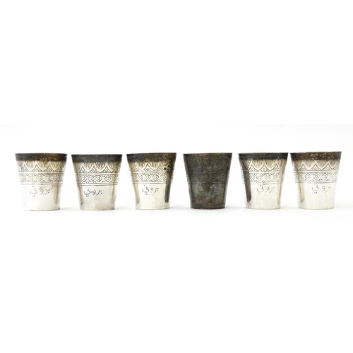 277 - A set of six white metal tot cups with engraved decoration and Persian style script. Approx 1 1/2