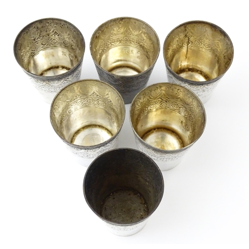 277 - A set of six white metal tot cups with engraved decoration and Persian style script. Approx 1 1/2