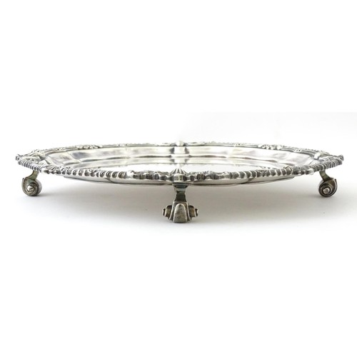 398 - A silver plate salver /card tray raised on four scrolling feet, marked Harrods. Approx. 8 3/4