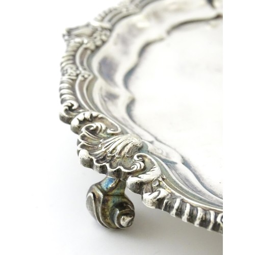 398 - A silver plate salver /card tray raised on four scrolling feet, marked Harrods. Approx. 8 3/4