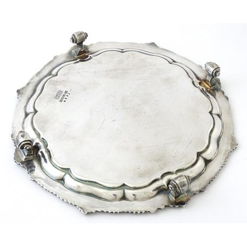 398 - A silver plate salver /card tray raised on four scrolling feet, marked Harrods. Approx. 8 3/4