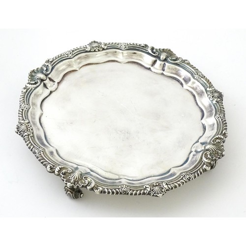 398 - A silver plate salver /card tray raised on four scrolling feet, marked Harrods. Approx. 8 3/4