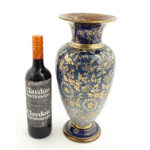 103 - A Doulton Lambeth vase decorated with flowers and foliage, having gilt highlights. Marked under with... 