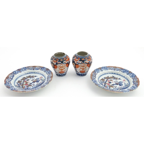 66 - A pair of Japanese vases decorated in the Imari palette decorated with flowers and foliage. Together... 
